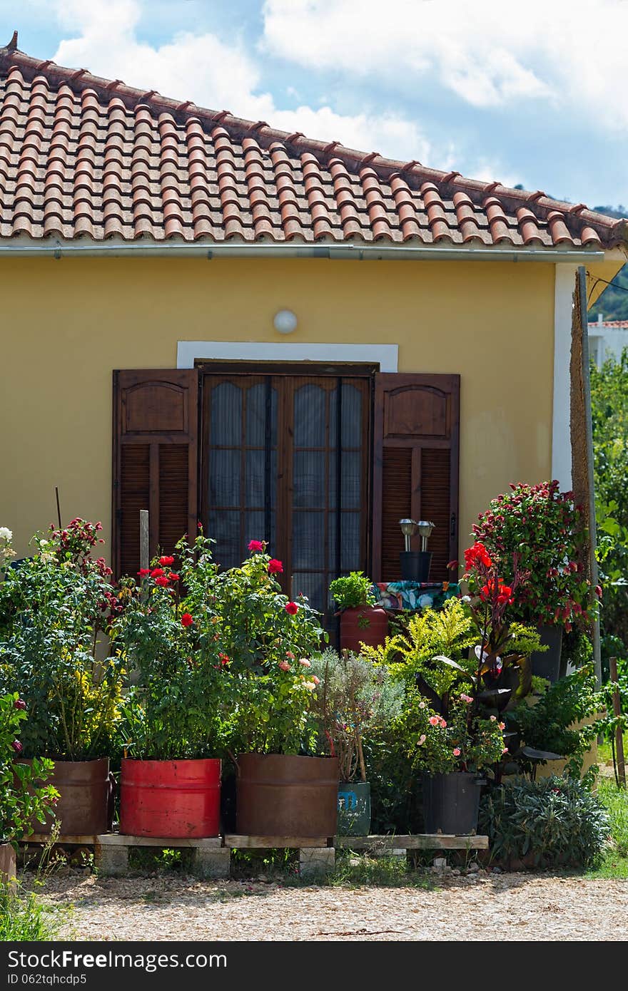 Small, beautiful house with flowers in front of the Windows