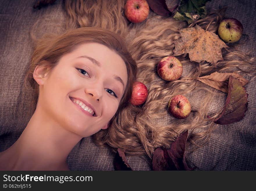 Autumn beauty woman portrait with fruits and leaves in her golden hair