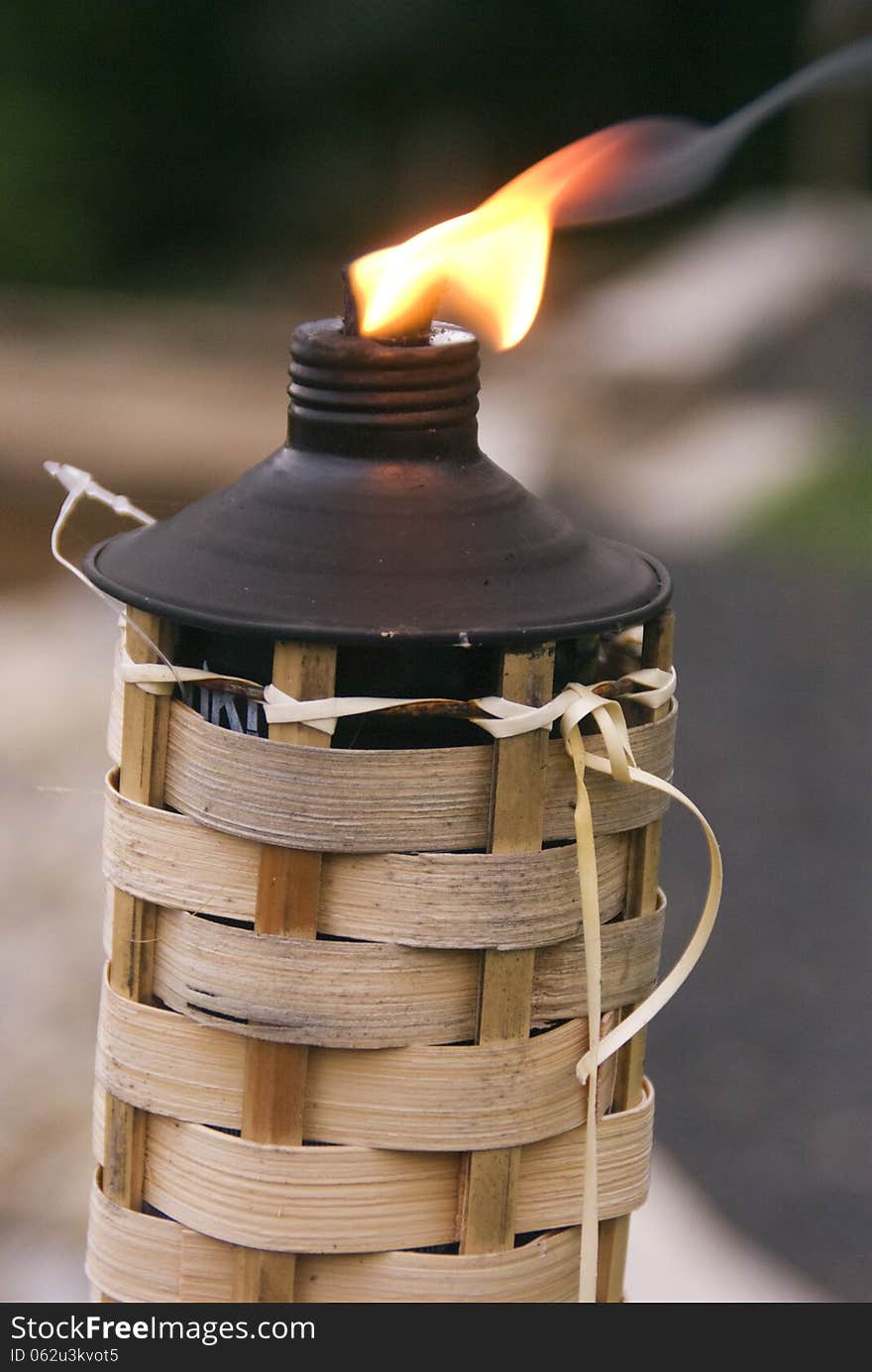 A Tiki Torch burns at a weekend gathering to ward off insects. A Tiki Torch burns at a weekend gathering to ward off insects.