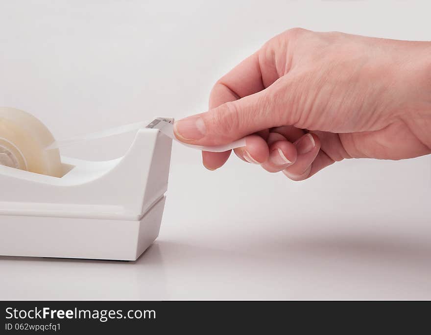 Hand of office worker tearing off tape. Hand of office worker tearing off tape