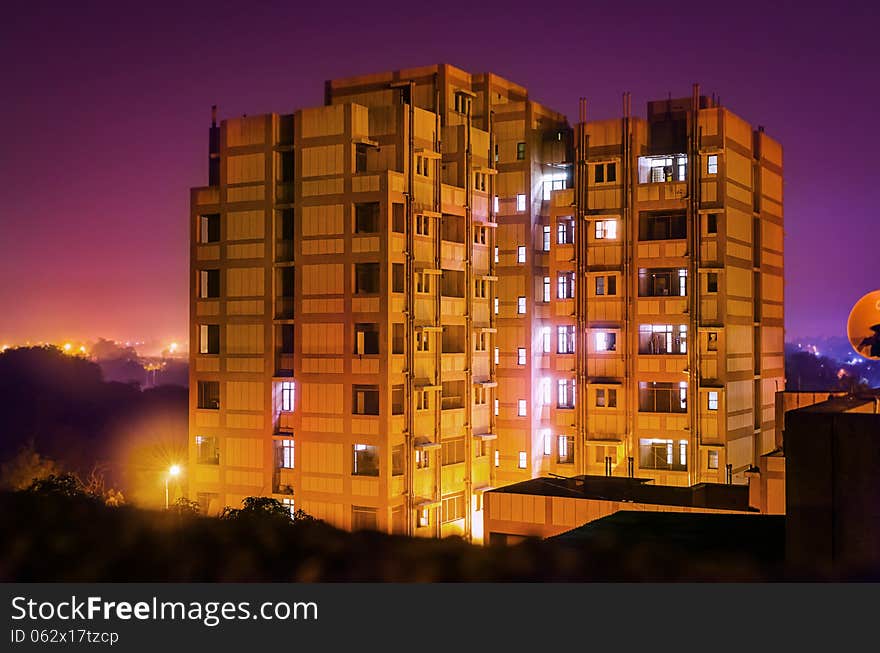 Hostel or residence building at night with ambient purple light in the sky