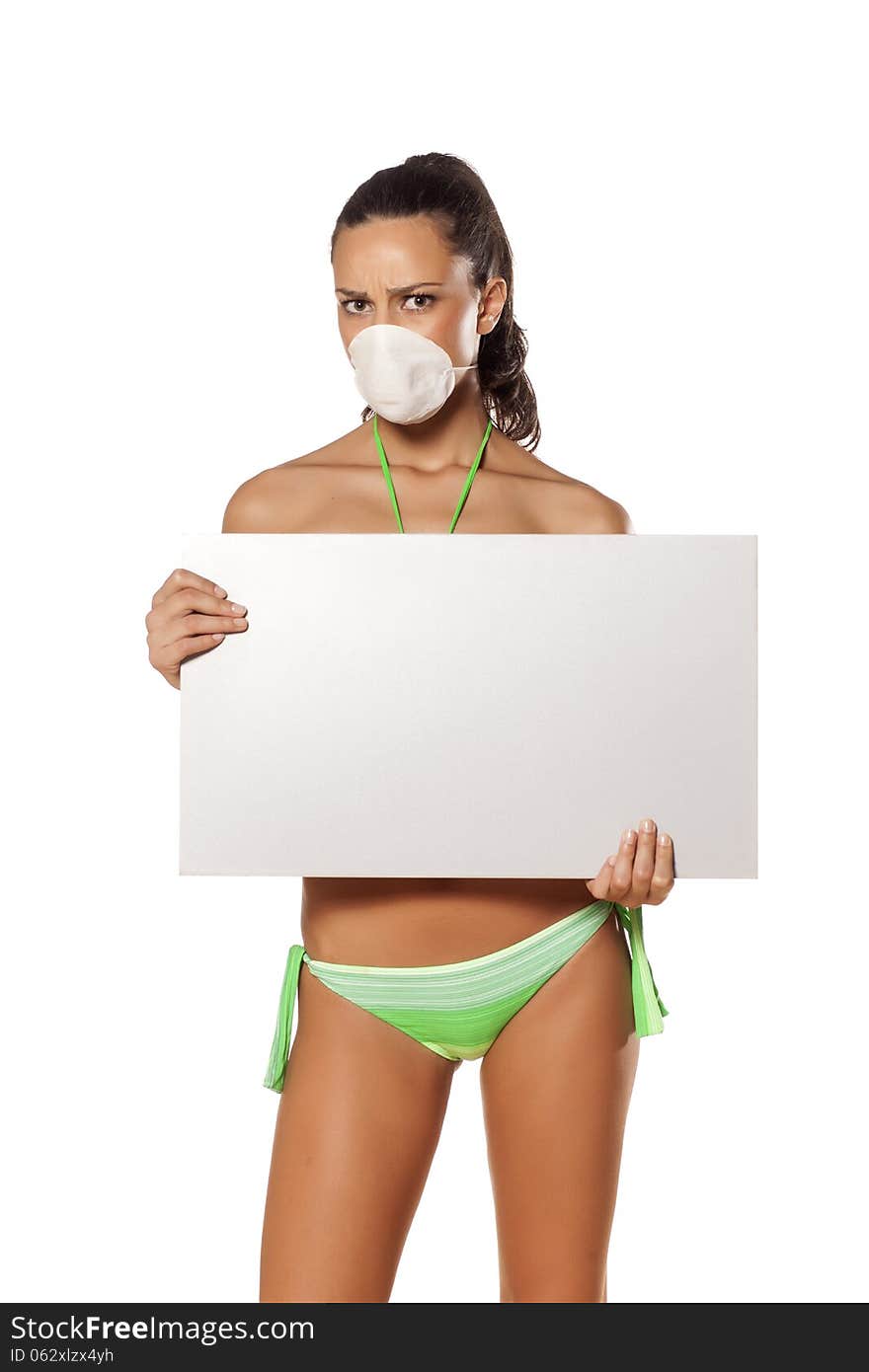 Beautiful brunette with a breathing mask in a bikini holding a blank display and pointing a finger. Beautiful brunette with a breathing mask in a bikini holding a blank display and pointing a finger