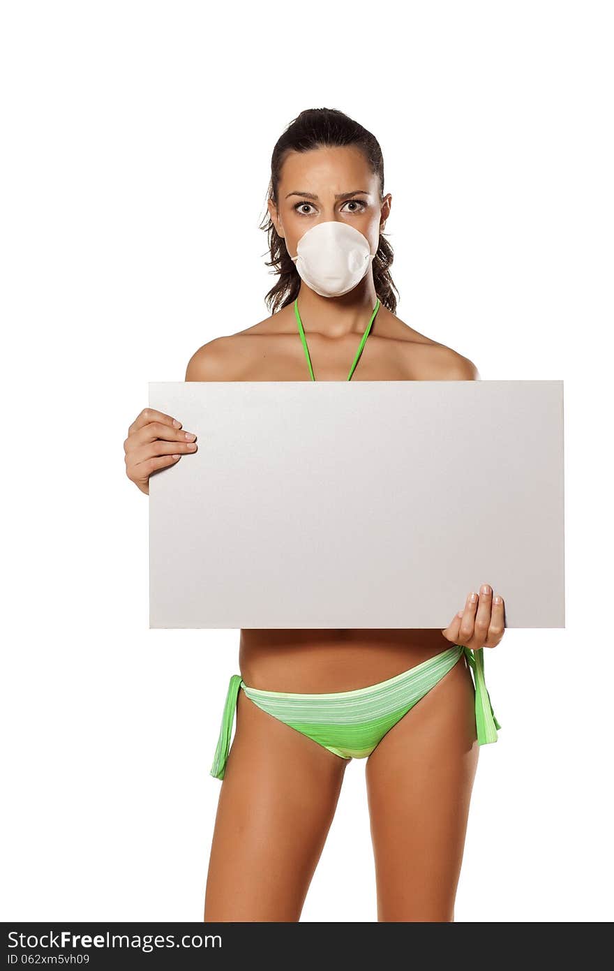 Beautiful brunette with a breathing mask in a bikini holding a blank display. Beautiful brunette with a breathing mask in a bikini holding a blank display