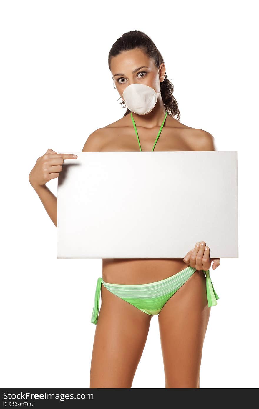 Beautiful brunette with a breathing mask in a bikini holding a blank display and pointing a finger. Beautiful brunette with a breathing mask in a bikini holding a blank display and pointing a finger