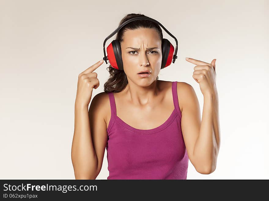 Beautiful scowling young brunette can not hear because of the anti loud headset. Beautiful scowling young brunette can not hear because of the anti loud headset