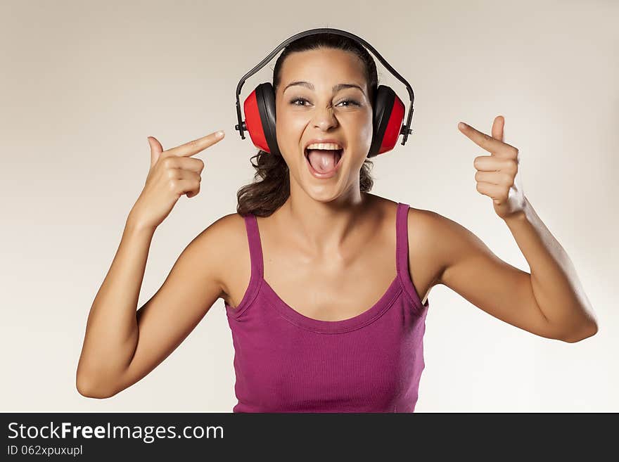 Beautiful happy young brunette can not hear because of the anti loud headset. Beautiful happy young brunette can not hear because of the anti loud headset