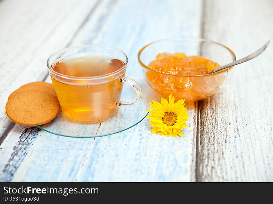 Orange jam and herbal tea on wooden table