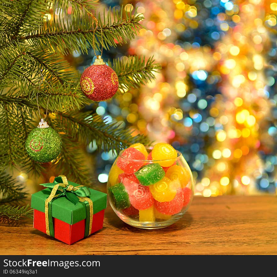 Colorful new year still life with bowl of sweets and cute gift box on blurred background. Colorful new year still life with bowl of sweets and cute gift box on blurred background