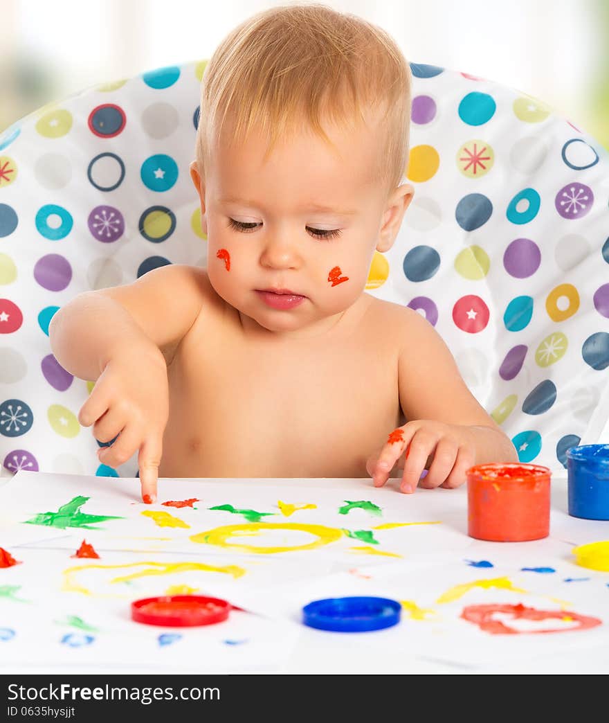 Happy child draws with colored paints hands