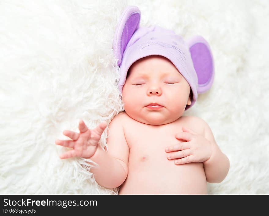 Cute newborn baby sleeps in a mouse hat with ears