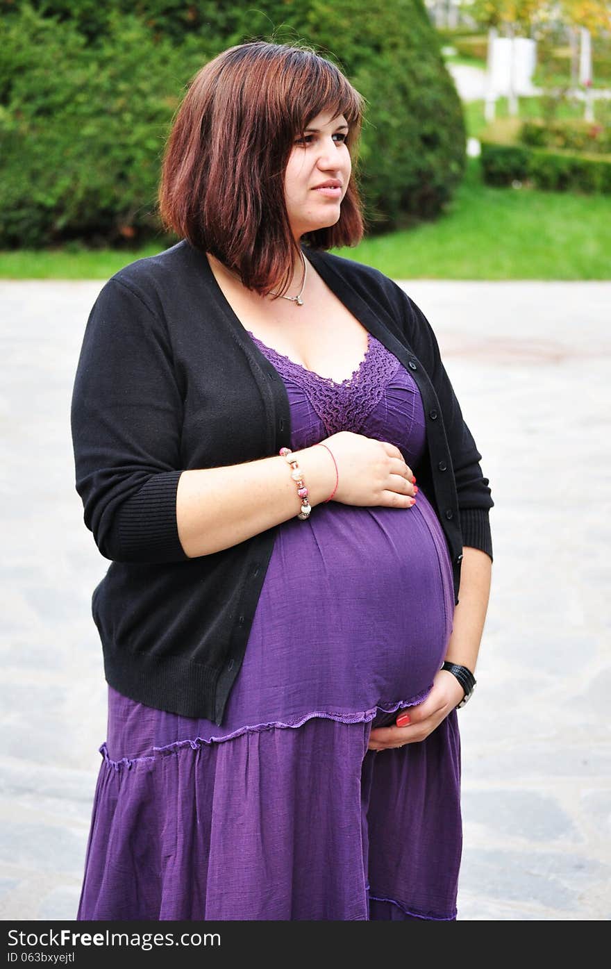 Happy pregnant woman in park.