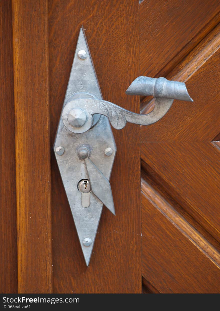 Wrought iron door handle old historic building with an interesting label. Wrought iron door handle old historic building with an interesting label