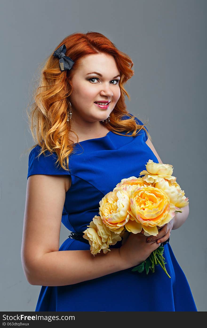 Attractive red-haired girl holding a bouquet of yellow flowers. Attractive red-haired girl holding a bouquet of yellow flowers