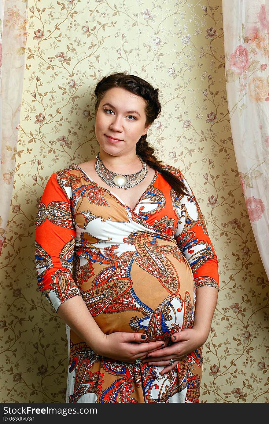 Attractive pregnant girl in a beautiful dress, shot in the studio. Attractive pregnant girl in a beautiful dress, shot in the studio