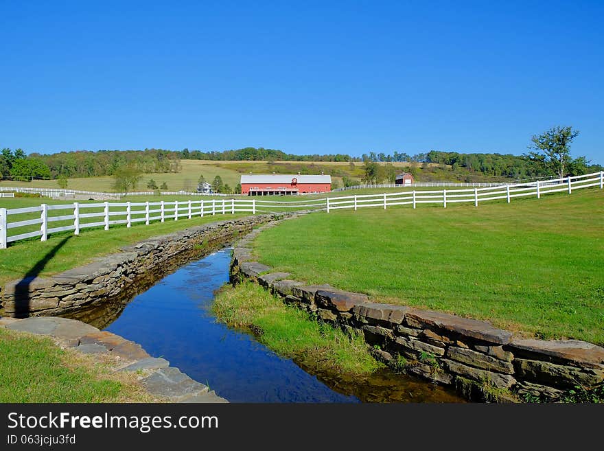 Landscape of ranch with white wooden rail fence and creek border. Mountains in northeast Pennsylvania. Landscape of ranch with white wooden rail fence and creek border. Mountains in northeast Pennsylvania.
