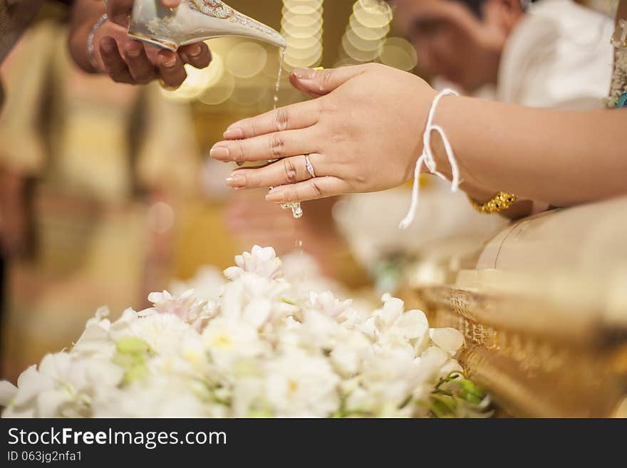 Hands pouring blessing water into bride's bands, Thai wedding ceremony. Hands pouring blessing water into bride's bands, Thai wedding ceremony