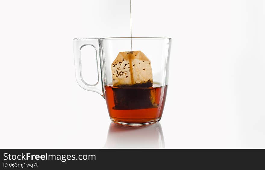 A red teabag in a crystal cup