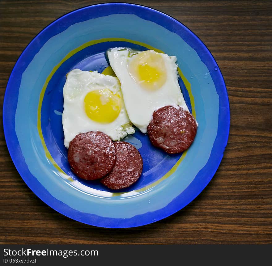 Fried eggs on a plate with slices of fried bacon