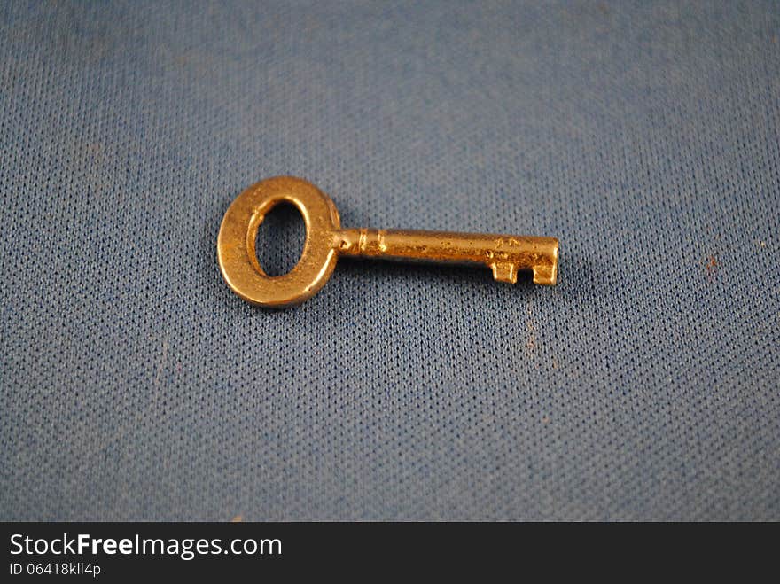 Brassy key on grey background. Brassy key on grey background.