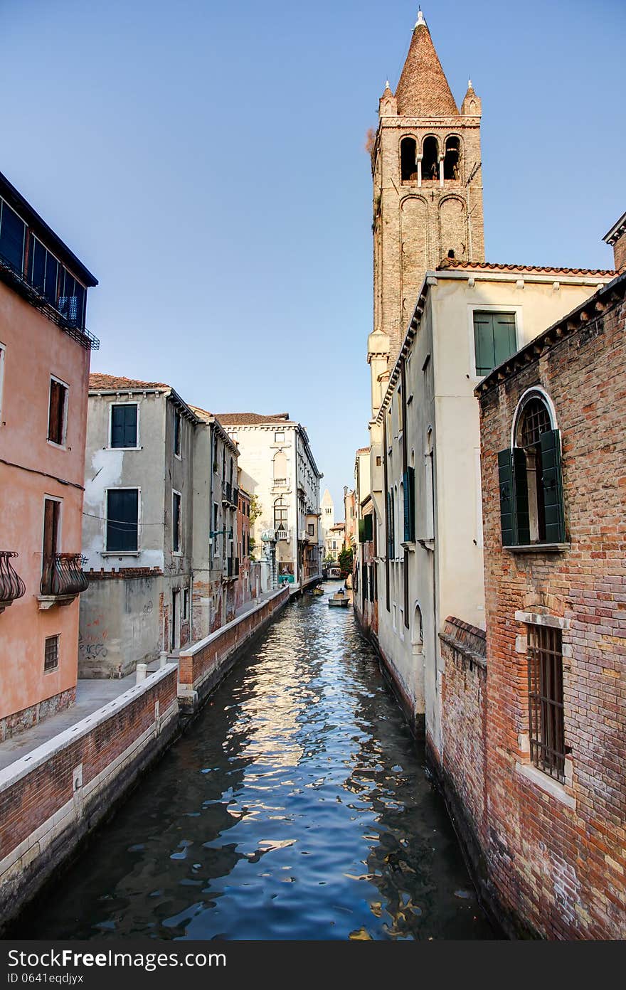 Canal in Venezia with a tower in the background