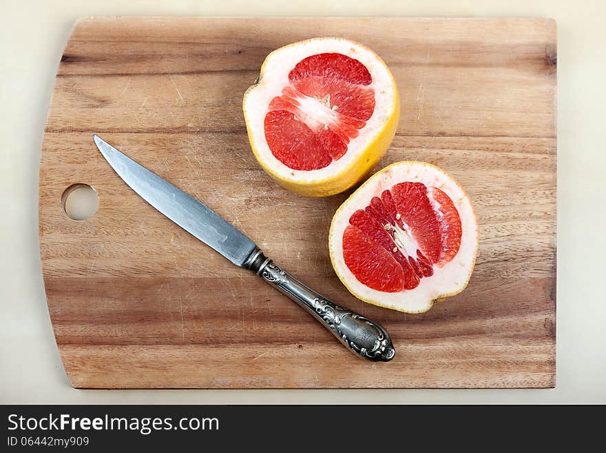 The cut grapefruit on a chopping board