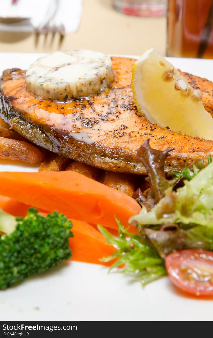 Grilled Butter Salmon with vegetables on a white plate