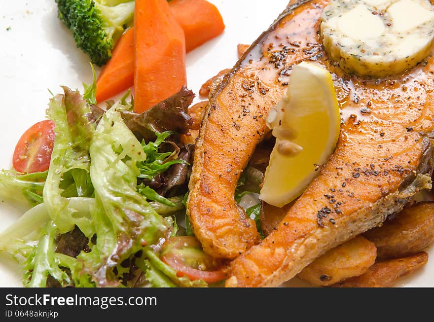 Grilled Butter Salmon with vegetables on a white plate