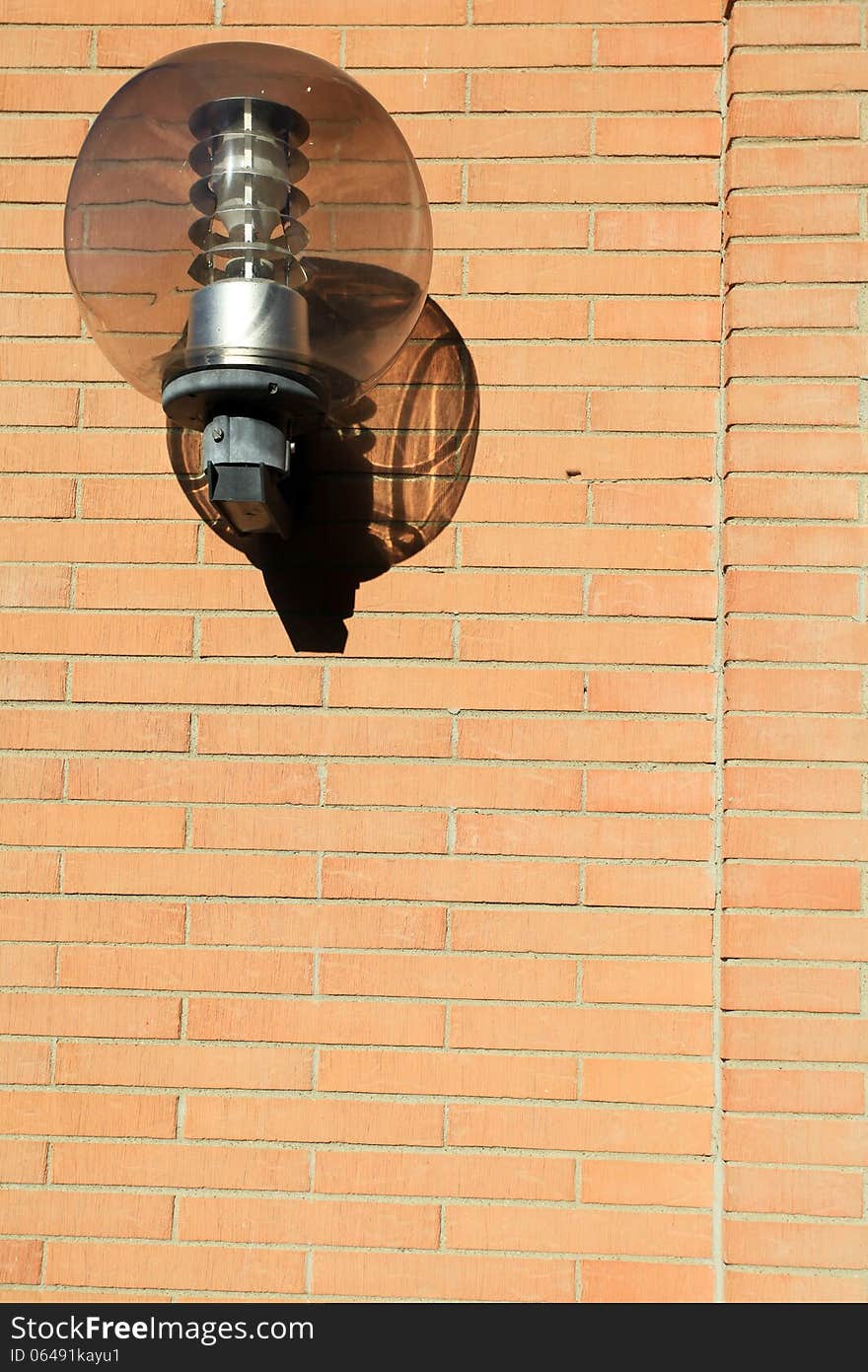 View of architectural detail of a wall of modern construction. In the picture you can see the red bricks used in some modern construction in Italy and a lamppost