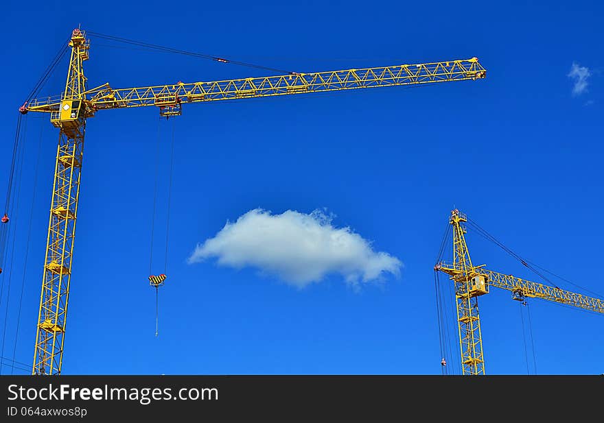 Cranes and cloud against the blue sky