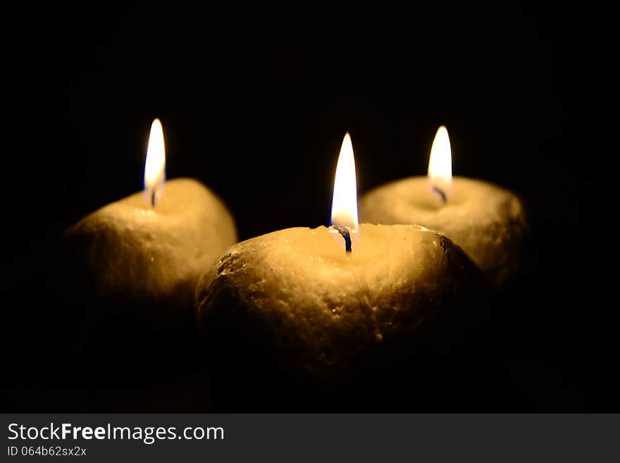 Photo of three candles isolated on the black background.