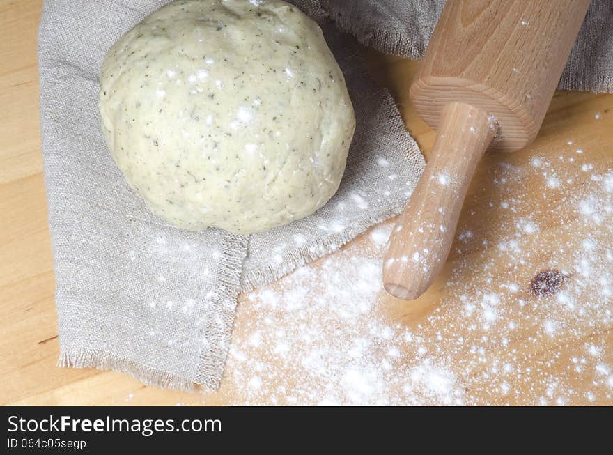 Dough, Rolling Pin And Flour On A Wooden Table.