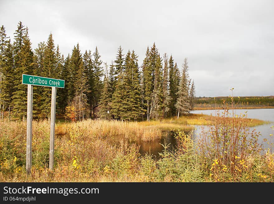 A Caribou Creek Sign In Front Of Trees