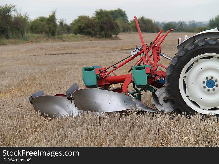 A Vintage Farming Plough Pulled by an Old Tractor. A Vintage Farming Plough Pulled by an Old Tractor.