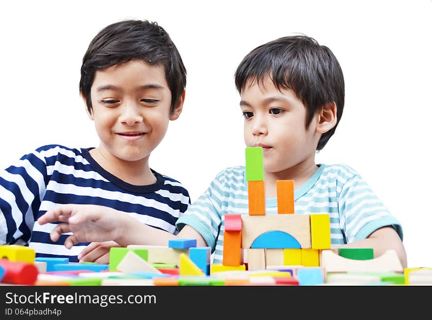 Little sibling boy play block on white background