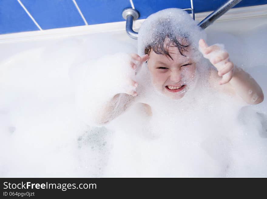 Little girl in bath. Soapsuds on all body and the head.