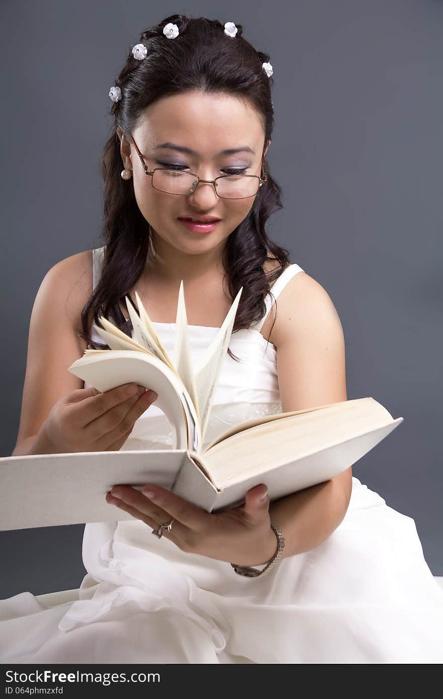 Asian girl in a white dress reads the book. Asian girl in a white dress reads the book