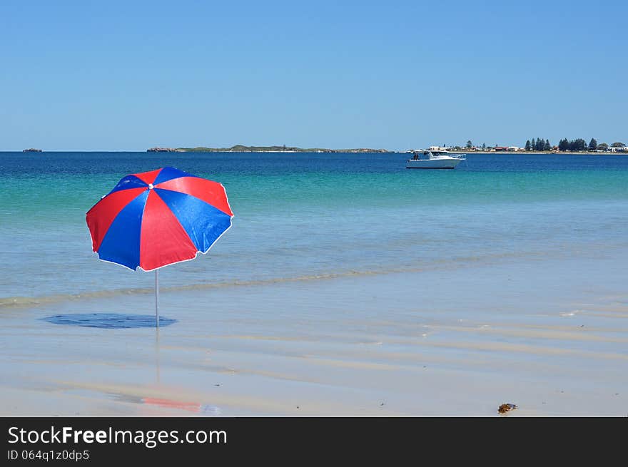 Beach umbrella set up on the beach by the sea with boat. Beach umbrella set up on the beach by the sea with boat