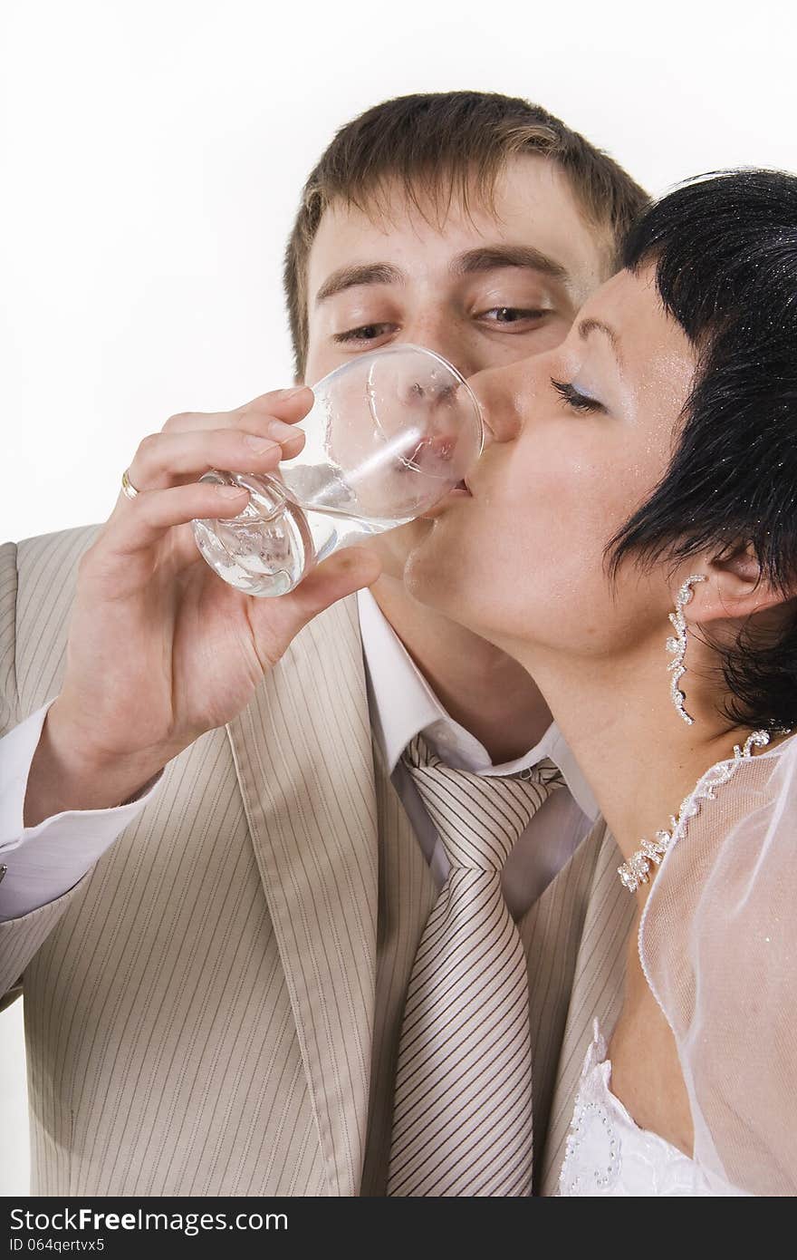 The groom and the bride drink water. White isolated.