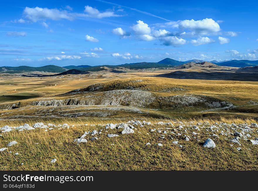 Mountain landscape, view on a mountain valley, distant road and shadows of clouds