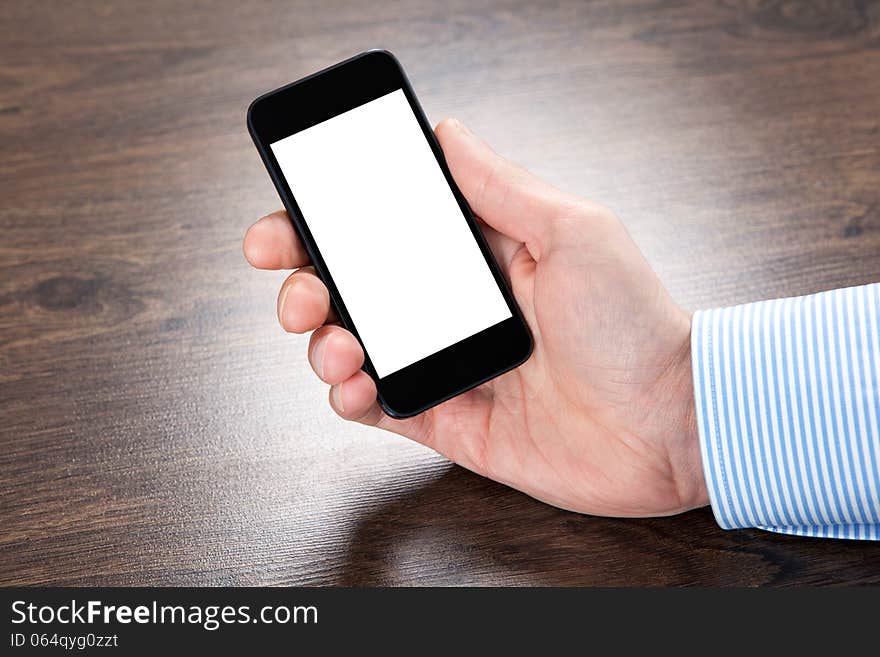 Businessman holding a touch phone with isolated screen over the villages table. Businessman holding a touch phone with isolated screen over the villages table