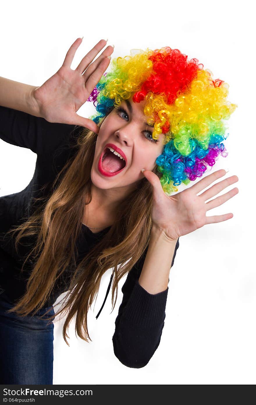 On the head of the cheerful girl multi-colored wig. Isolated on white.