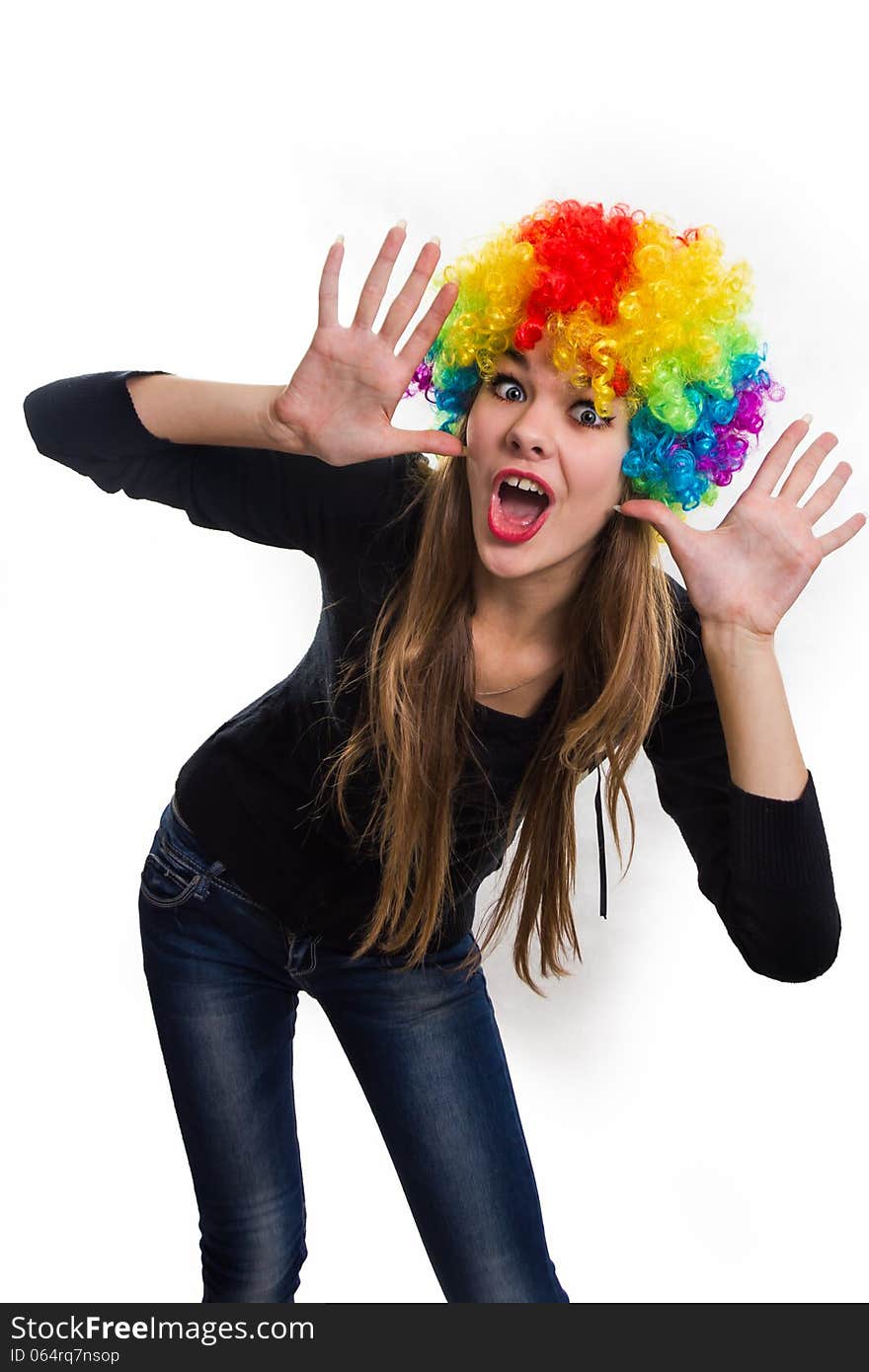 On the head of the cheerful girl multi-colored wig. Isolated on white. On the head of the cheerful girl multi-colored wig. Isolated on white.