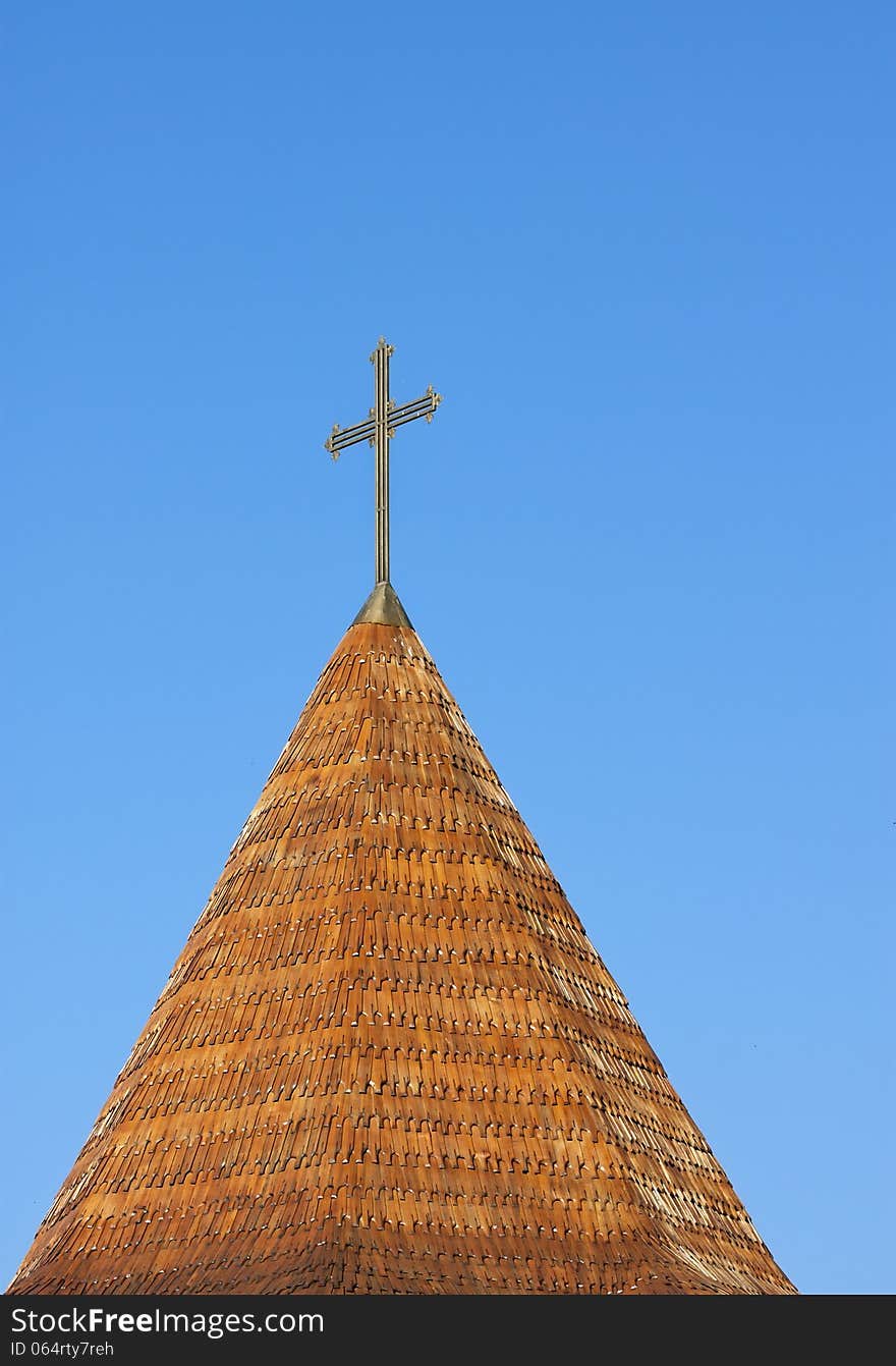 Cross in top of a roof tower on the blue sky. Cross in top of a roof tower on the blue sky