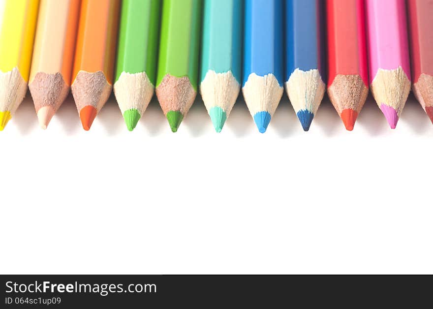 Colored pencils arranged in a circle on an white background