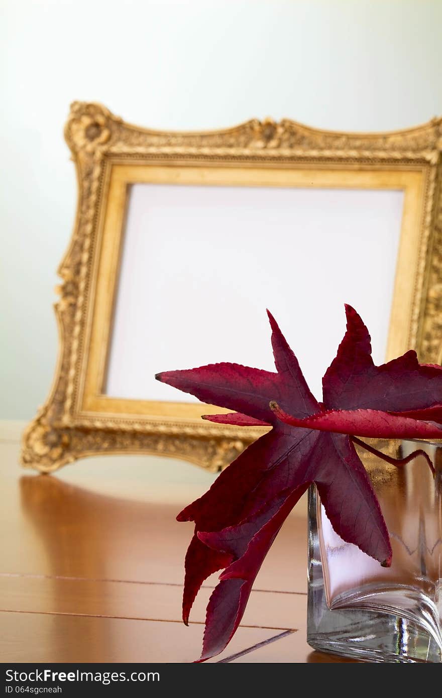 Autumn leaves in a glass vase and a photo frame in retro style. Autumn leaves in a glass vase and a photo frame in retro style