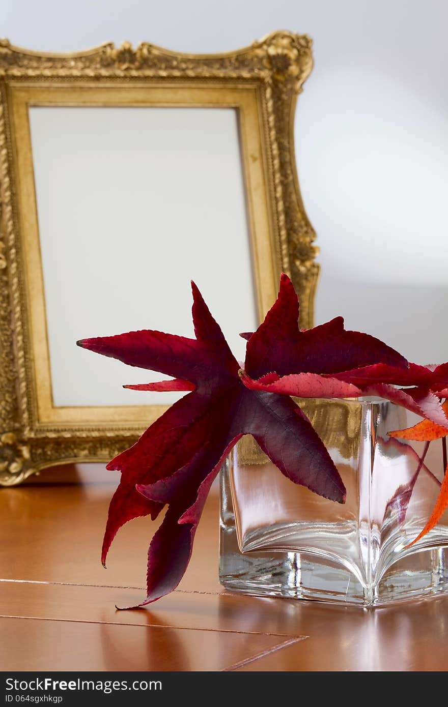 Autumn leaves in a glass vase and a photo frame in retro style. Autumn leaves in a glass vase and a photo frame in retro style