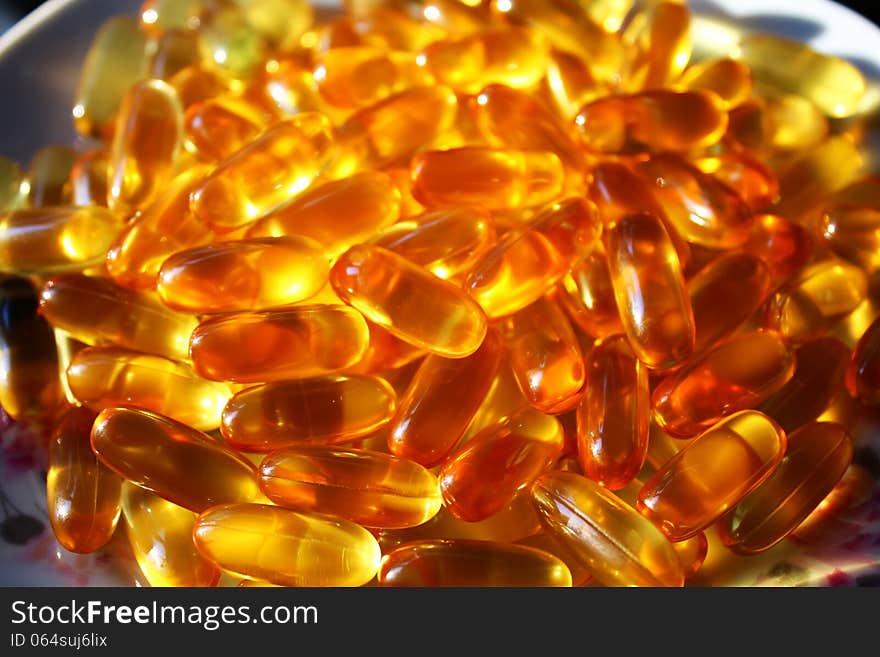 Amber pile of gel vitamin fish oil supplement capsules