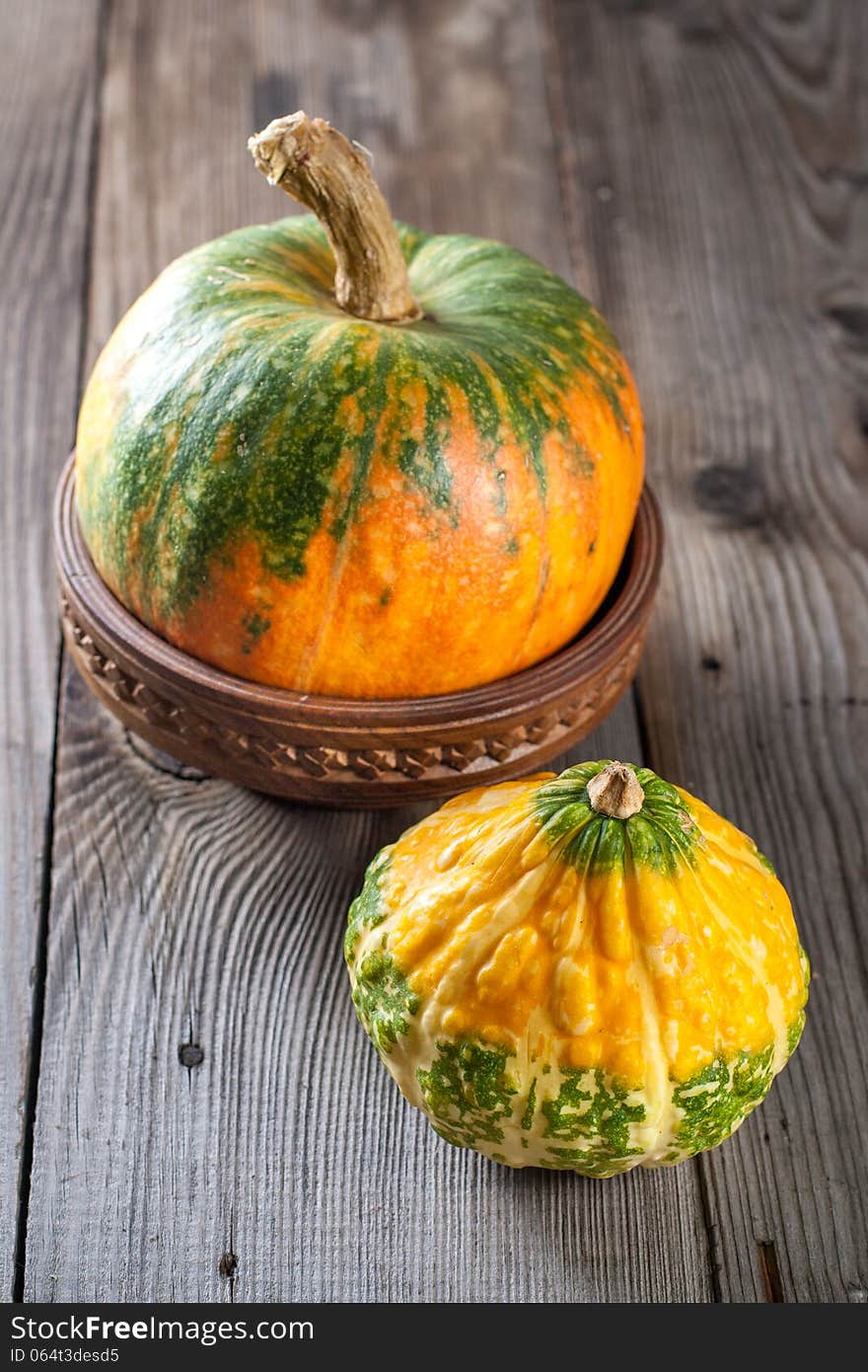 Autumn pumpkins with leaves on wooden board