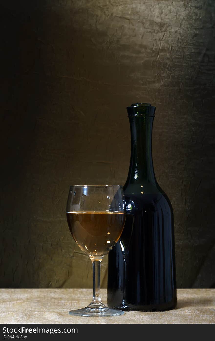 Bottle and glass of white wine on a old stone background. Bottle and glass of white wine on a old stone background