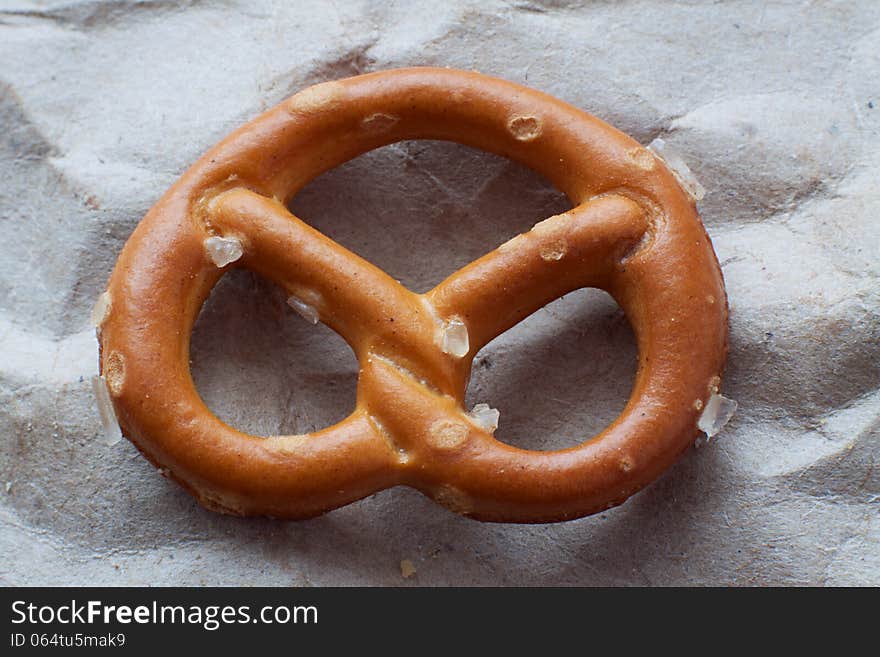 Salty pretzel the background paper closeup